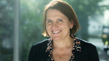 Claudia Felser im Porträt vor verschwommenem Hintergrund, draußen bei Tageslicht.